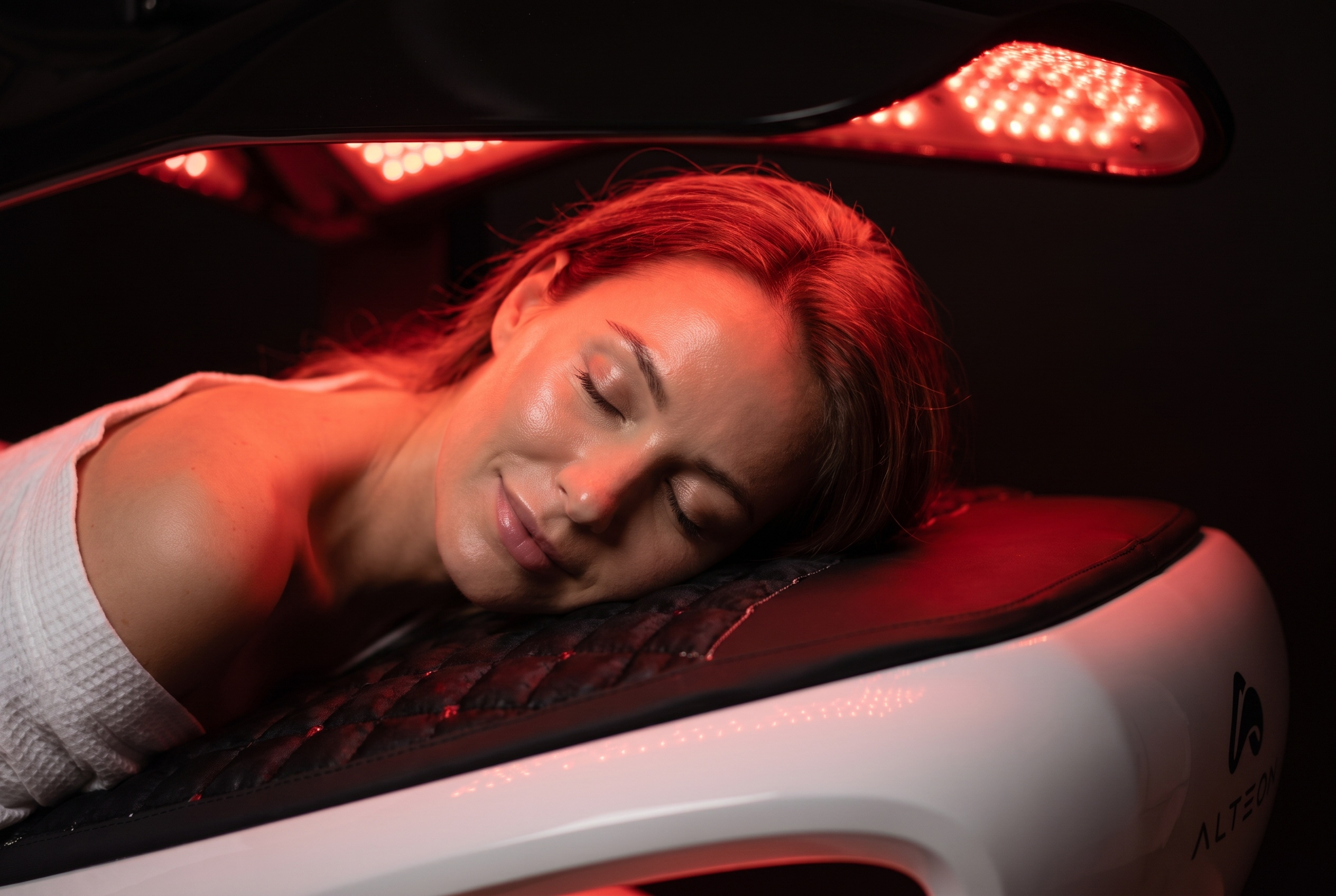 A patient resting inside a red light therapy bed